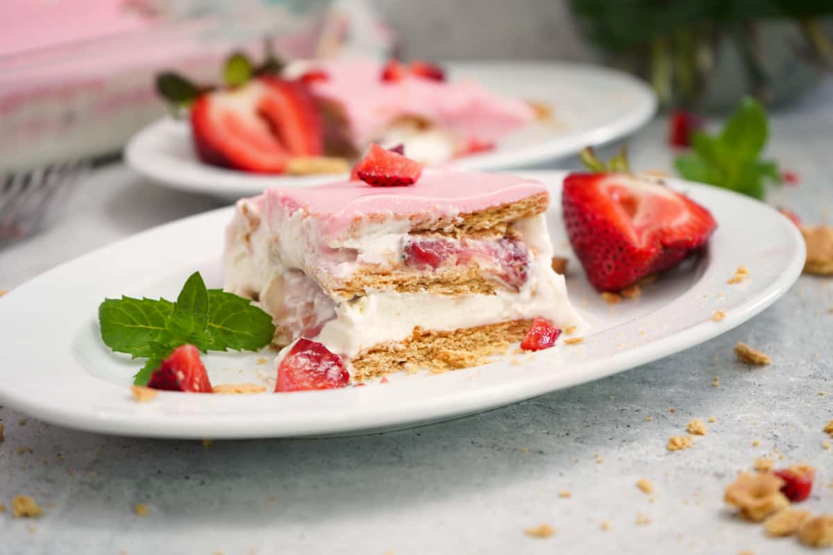 Strawberries N Cream Éclair Cake on white plate.