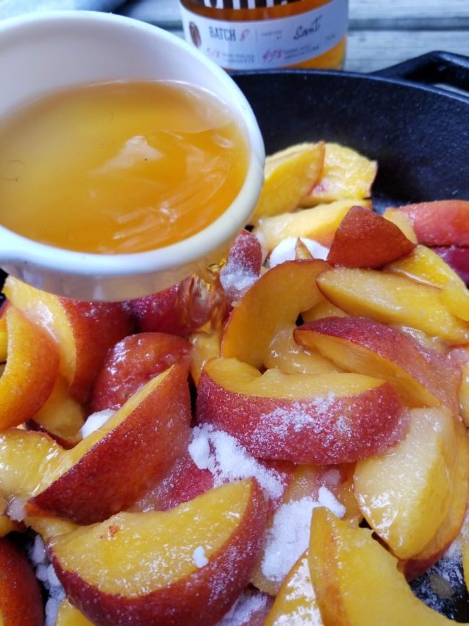 Sliced peaches with whiskey in cast iron skillet. 