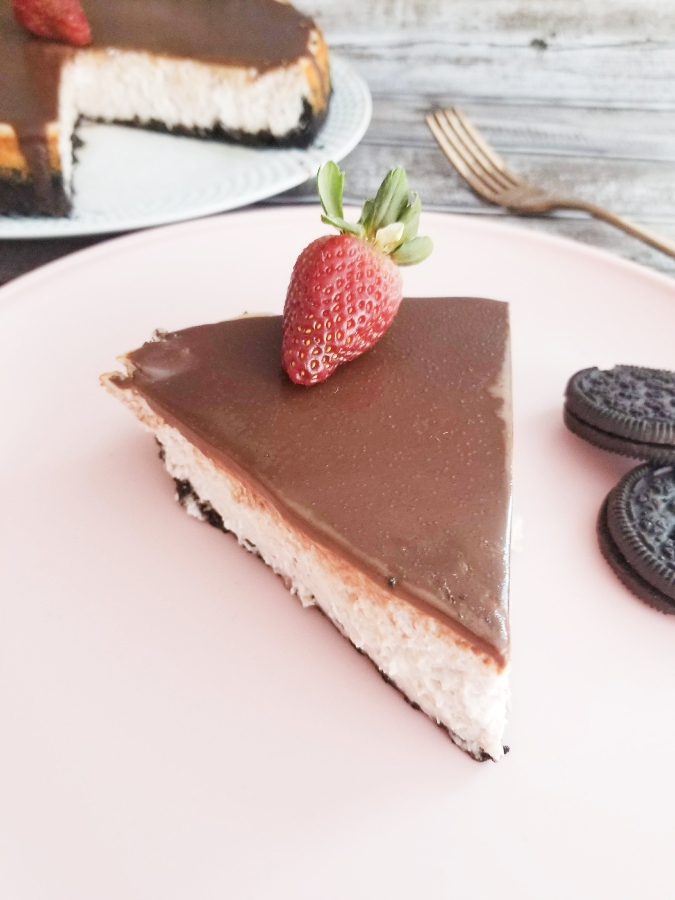 chocolate covered strawberry cheesecake slice on pink plate