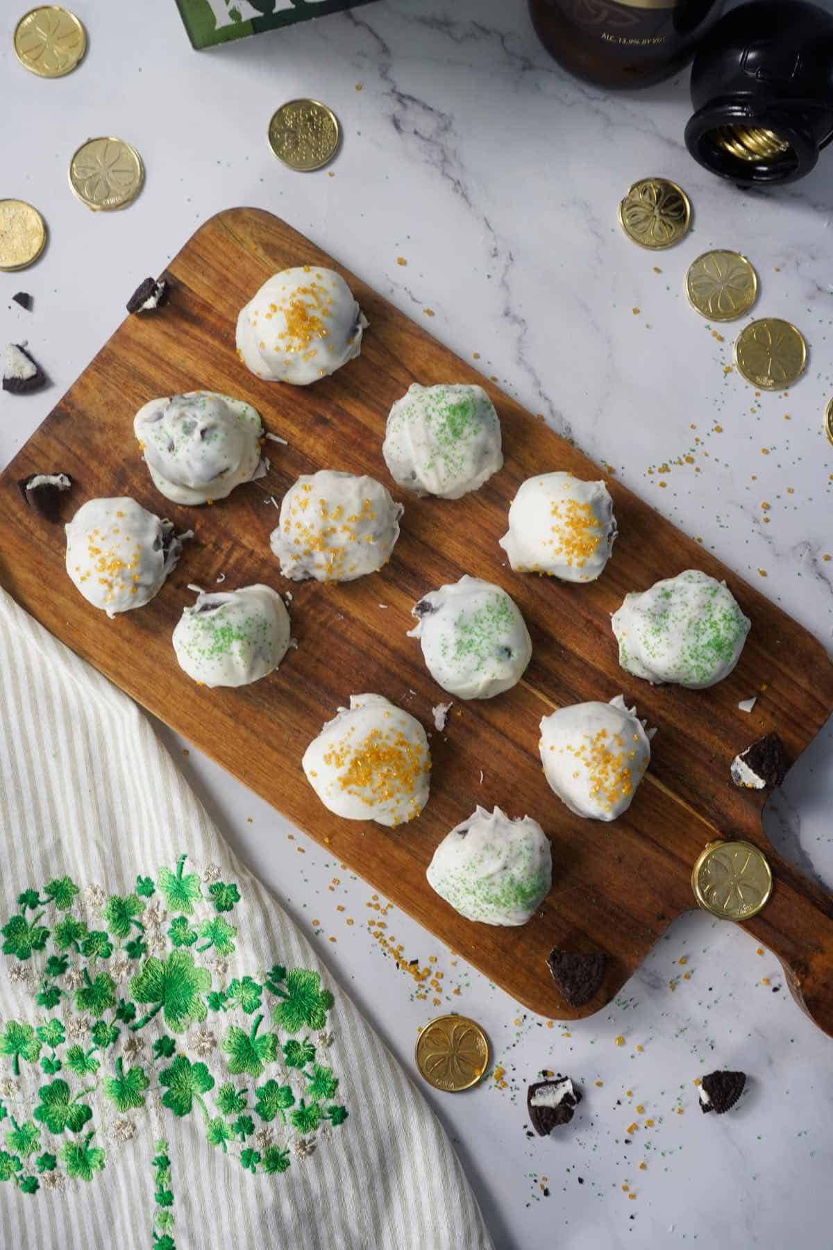 Irish Oreo Truffles served on wooden cutting board with gold coins around it