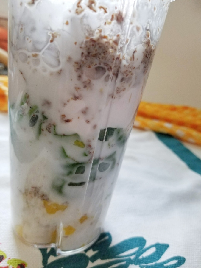 pineapple spinach smoothie ingredients in blender cup 