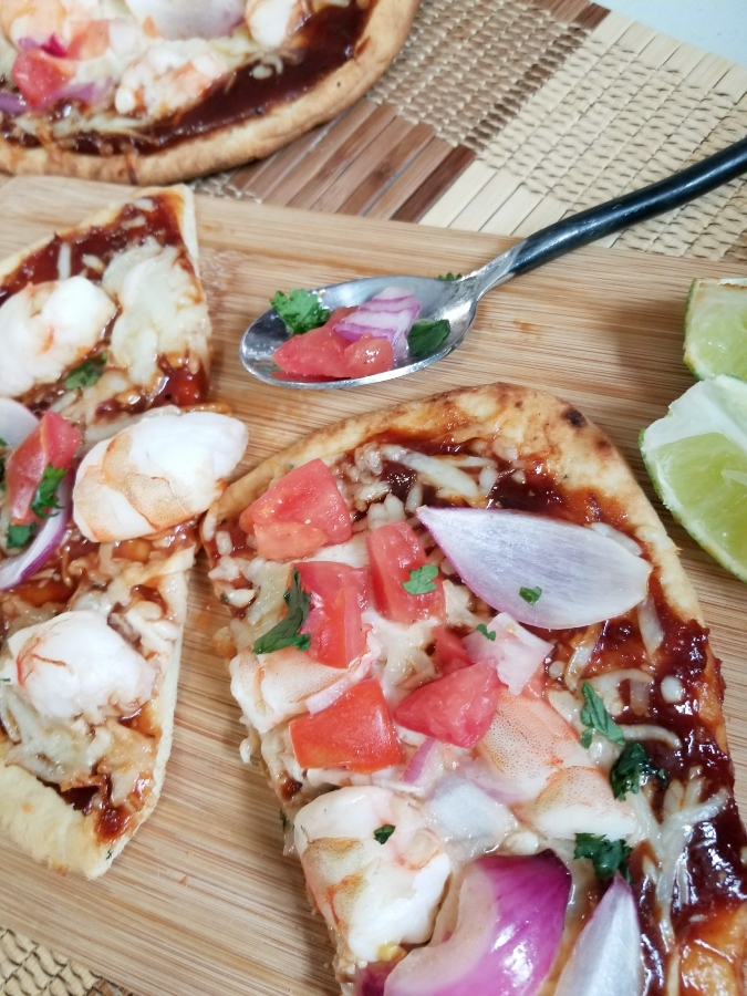 Easy BBQ Shrimp Pizza slices on cutting board 