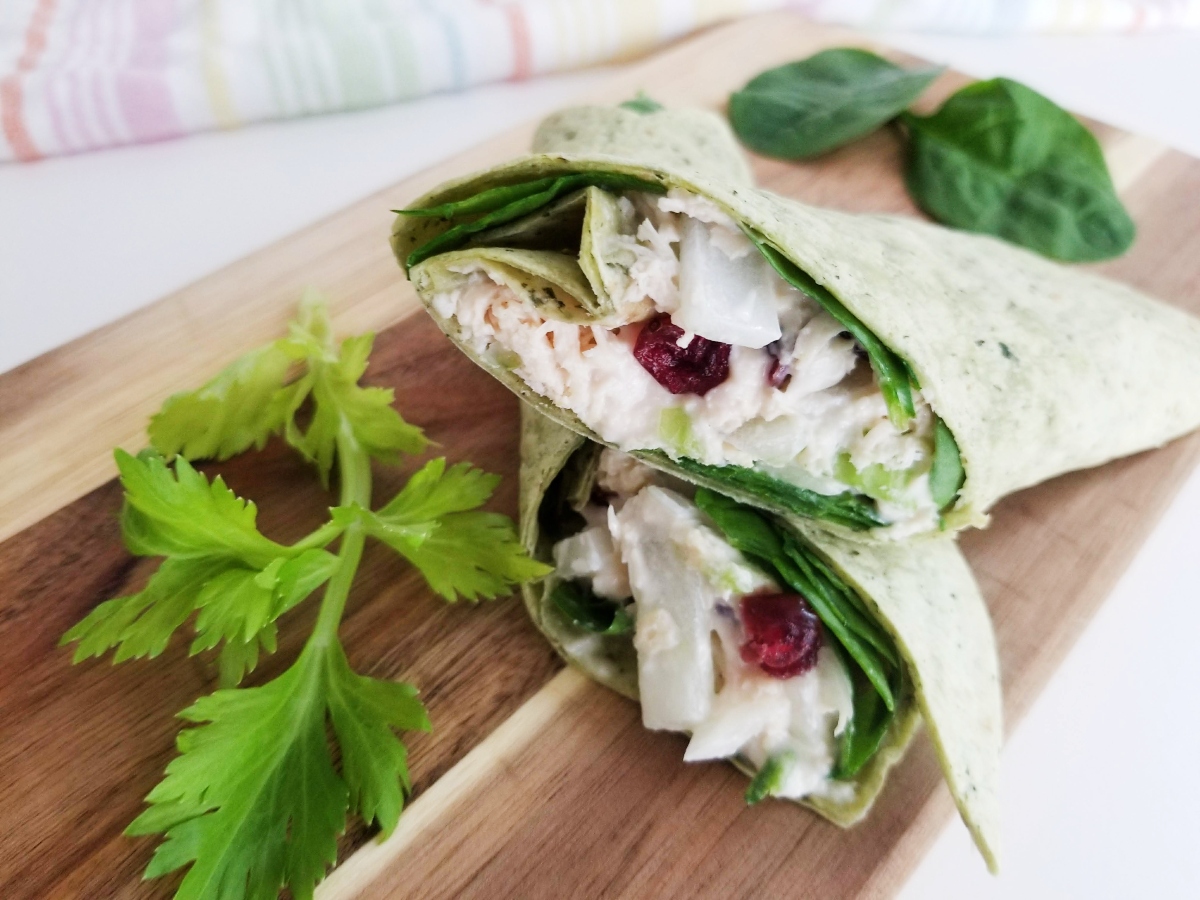 Cranberry Chicken Salad Spinach Wraps in cutting board with celery and spinach 