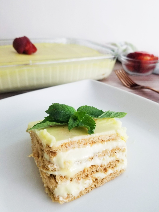 Lemon Eclair Cake on white plate with mint
