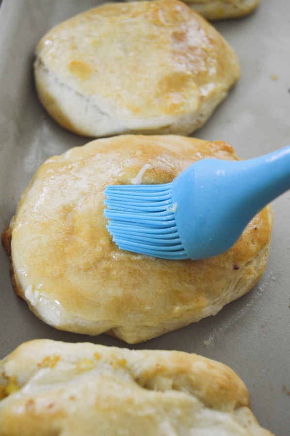 brushing butter on stuffed biscuits 