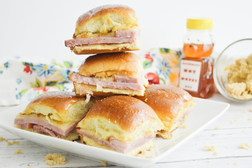 Hot Honey Ham & Swiss Sliders on white plate stacked 