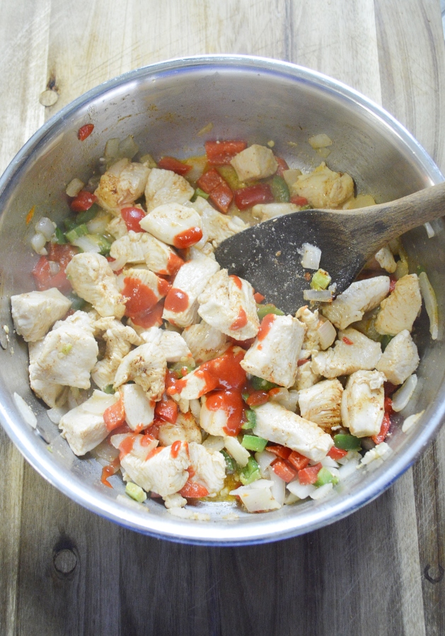 Spicy chicken cooked in pan with peppers and onions 