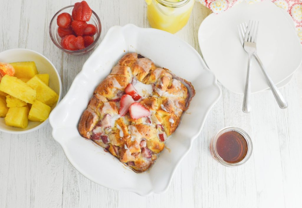 Strawberry Cinnamon Roll French Toast Casserole ariel shot with fruit and syrup 