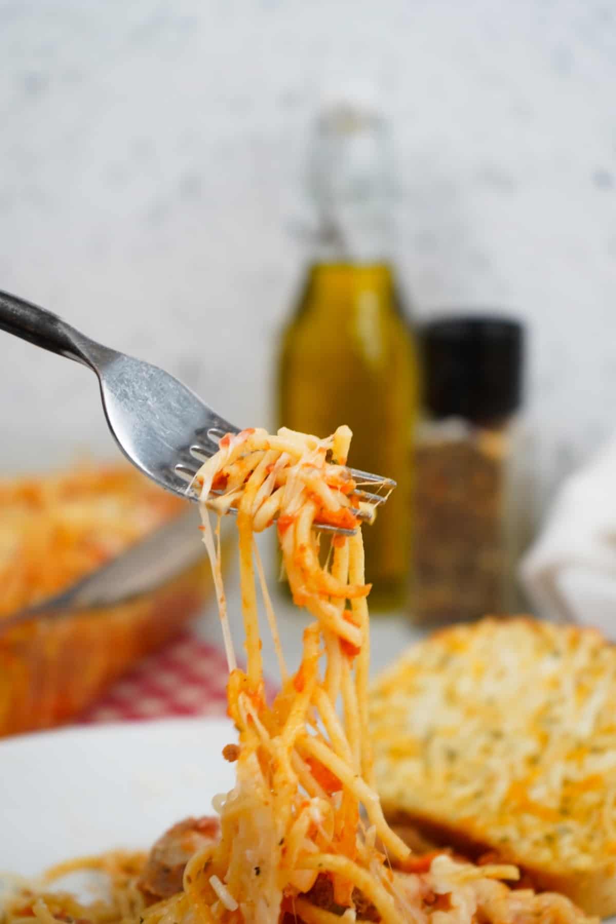 cheesy baked spaghetti on fork 