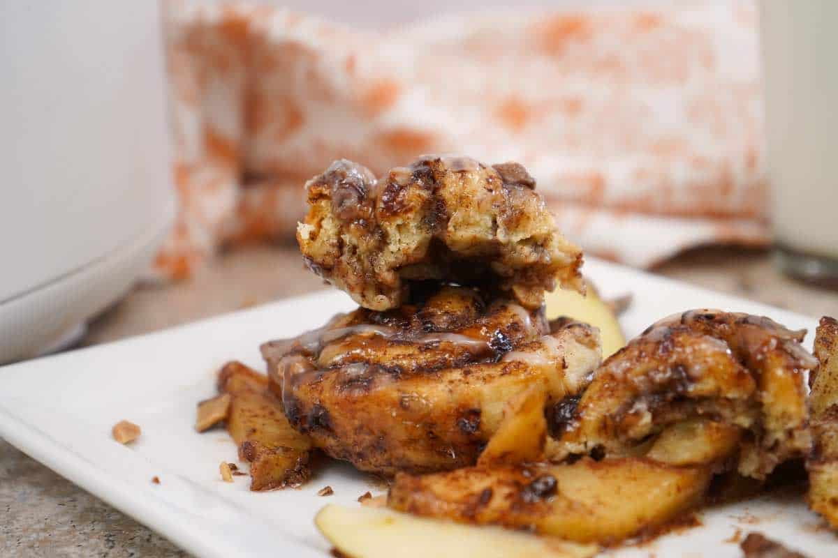 Cinnamon rolls stacked over cooked apples