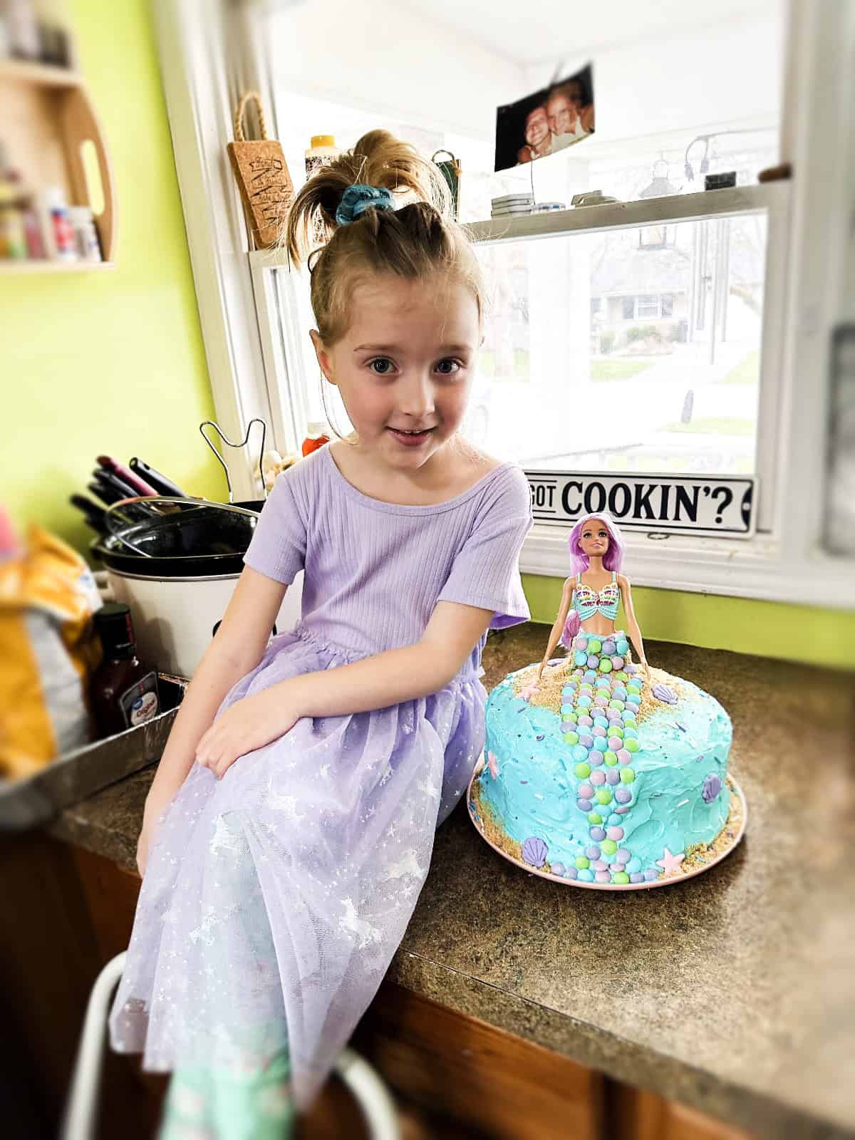 Daughter with mermaid birthday cake