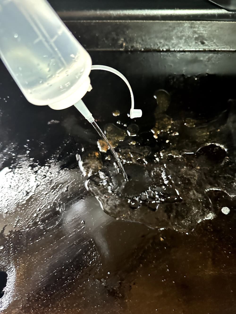 water bottle squirting water onto flat top