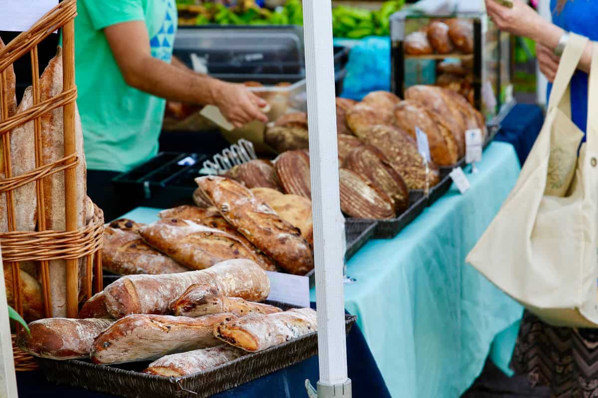 farmers market with person selling fresh bread