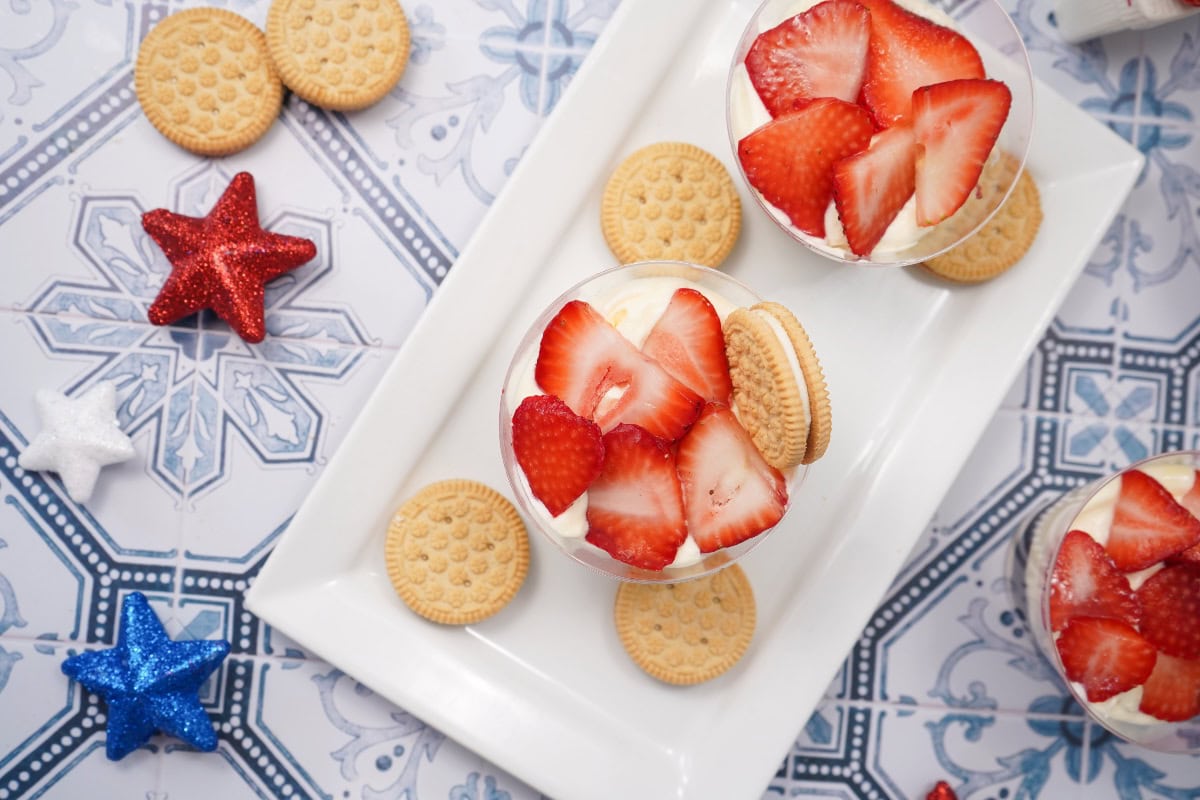Strawberries sliced on top of parfait cups 