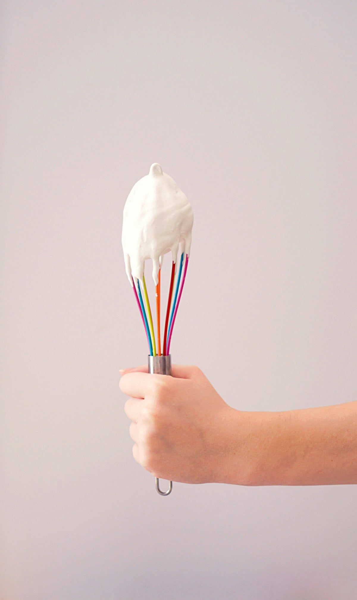hand holding colorful silicone whisk