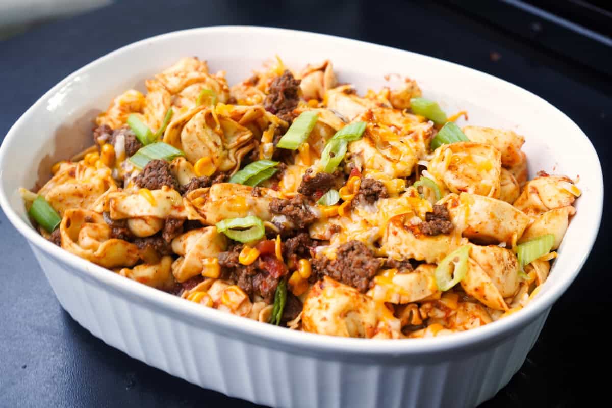 Taco Tortellini in white dish with green onions