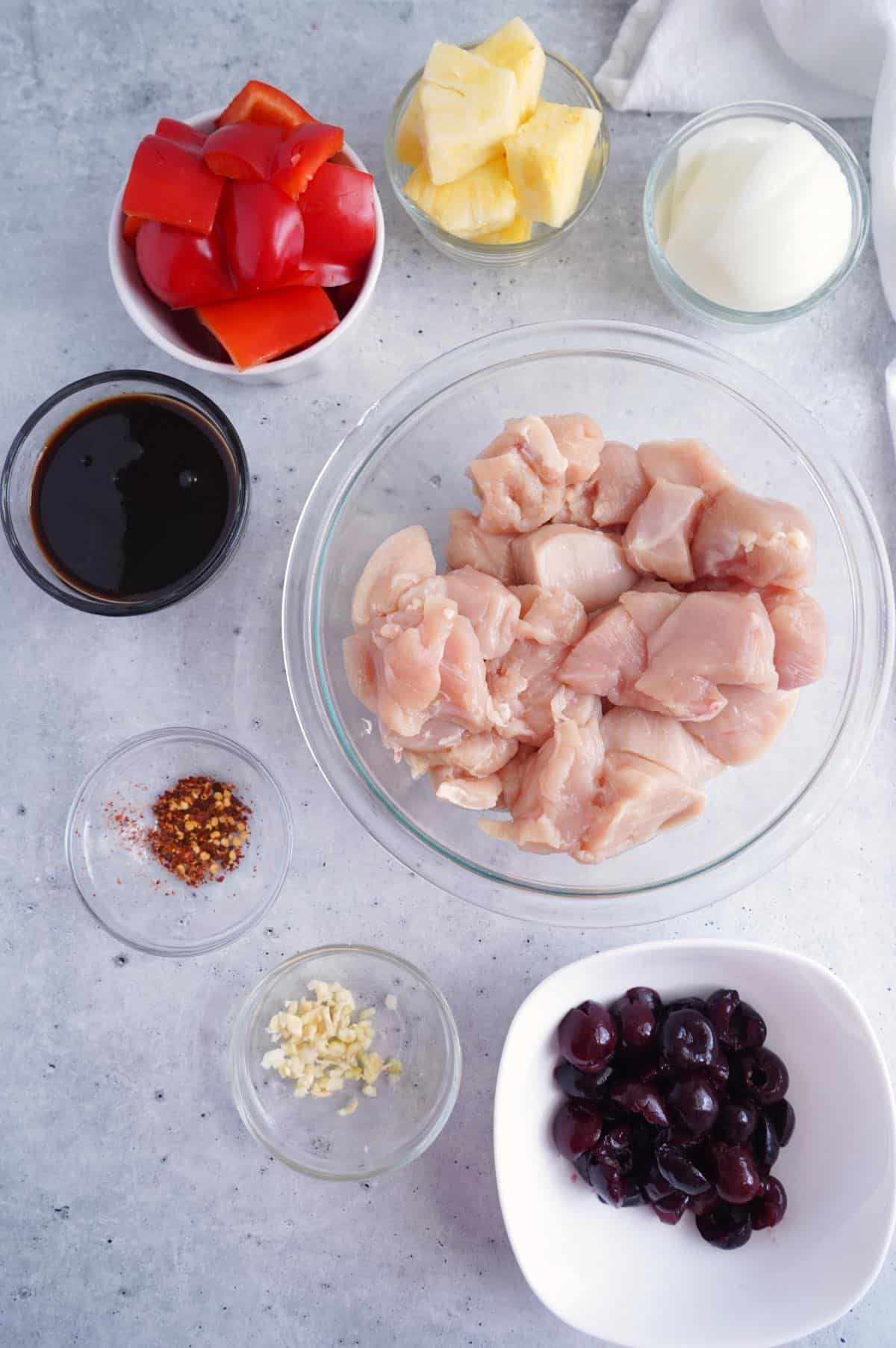 ingredients for cherry marinated chicken skewers on gray table.