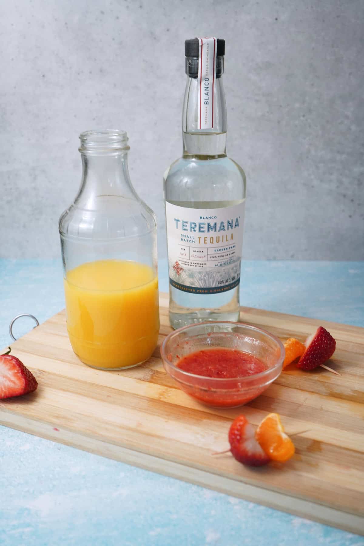strawberry tequila Sunrise ingredients on cutting board 