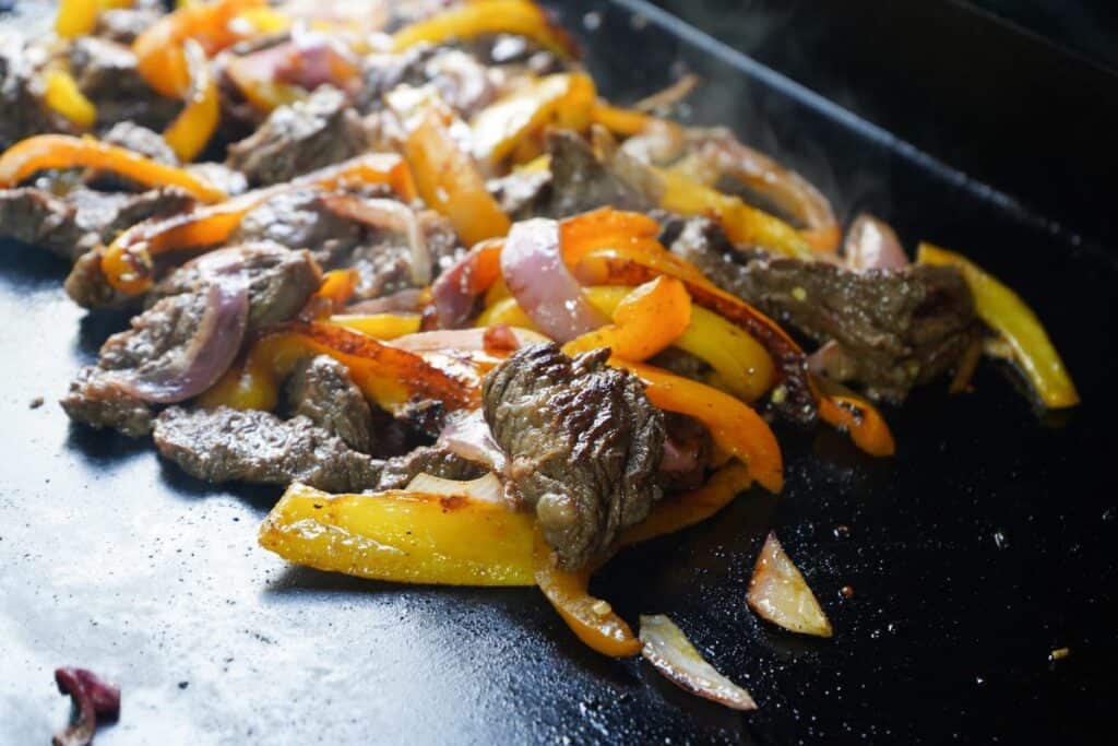 Fajita meat on flat top seared with caramelization 