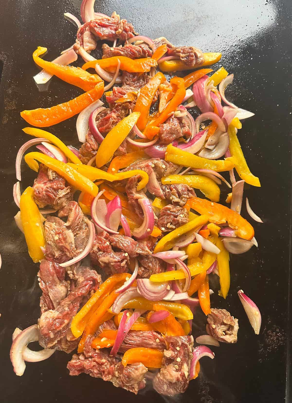 Fajita meat and peppers on griddle