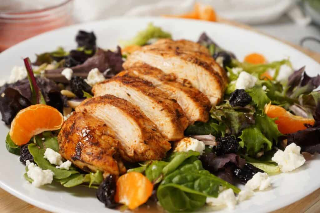 sliced grilled blackened chicken over salad.