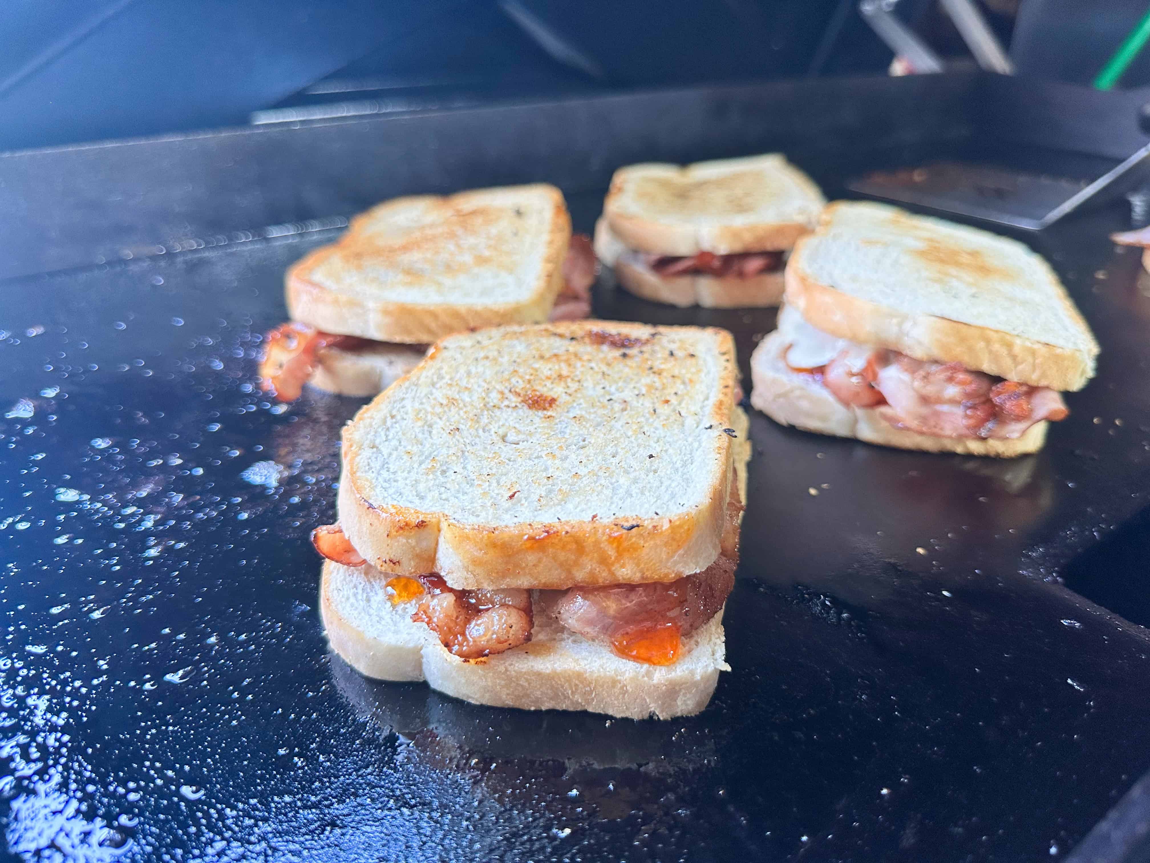 Four sandwiches on flat top surface. 