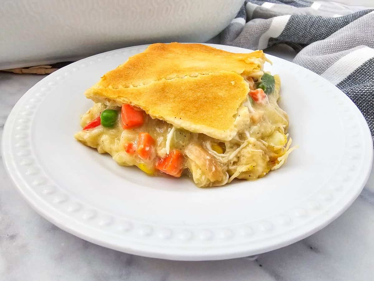 One slice of chicken pot pie casserole on white plate.