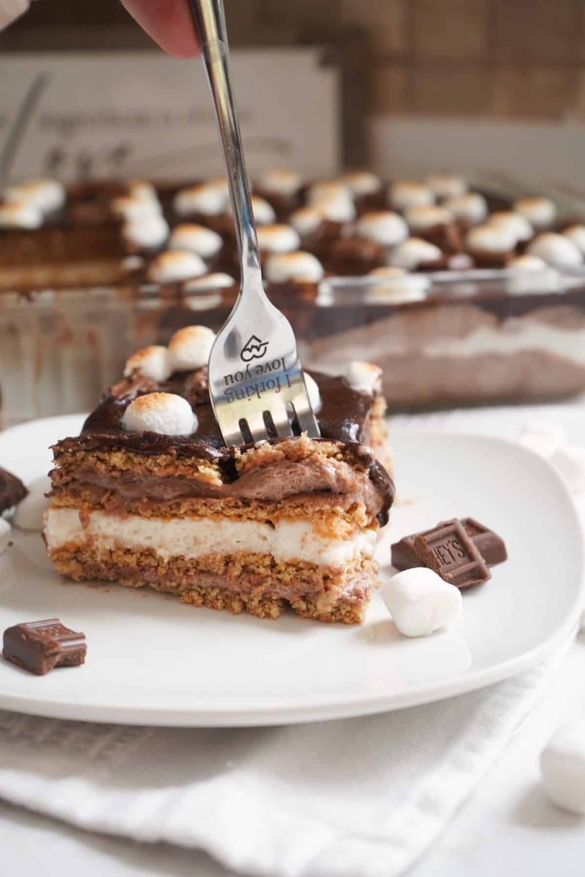 Fork digging in to s'mores eclair cake.