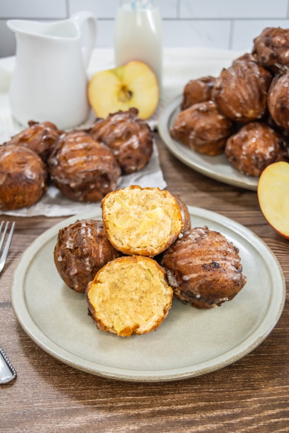 Homemade apple fritters stacked on plate.